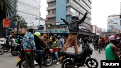 A person stands on a motorbike as pro-government protesters parade to counter an anti-government demonstration, following nationwide deadly riots over tax hikes, in Nairobi, Kenya, July 23, 2024. 