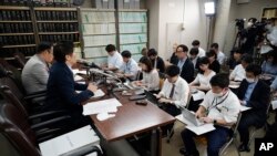 Lawyers of a claimant, Kazuyuki Minami, left, and Masafumi Yoshida, right, speak to media after the ruling of the Supreme Court, Oct. 25, 2023, in Tokyo.