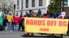 Los manifestantes sostienen una pancarta durante una protesta frente al edificio de oficinas del Senado Dirksen, el miércoles 8 de marzo de 2023, en Capitol Hill en Washington.