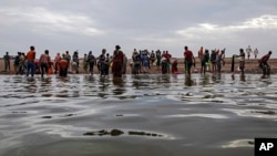 In this file photo, Ethiopian migrants walk on the shores of Ras al-Ara, Lahj, Yemen, after disembarking from a boat, July 26, 2019. (AP Photo/Nariman El-Mofty, File)