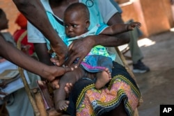 FILE - A baby from Malawi is injected with the world's first vaccine against malaria on Dec. 11, 2019. The WHO approved a second malaria vaccine that could offer a cheaper and more effective shot against the parasitic disease. (AP Photo/Jerome Delay, File)