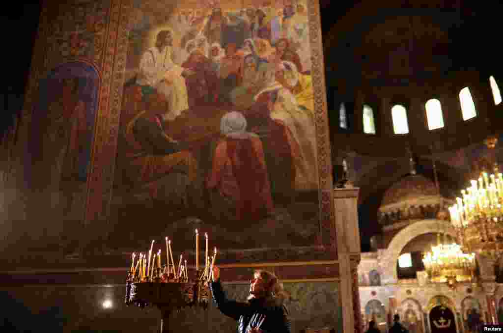 A woman lights a candle as she attends a mass on Christmas Day at St. Alexander Nevsky Cathedral in Sofia, Bulgaria.