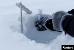 Paul Scherrer Institute Switzerland chemist Francois Burgay takes a snow sample to detect molecules connected to algal bloom in Ny-Aalesund, April 5, 2023.