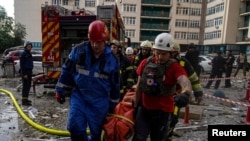 2023 年 6 月 24 日，俄罗斯导弹袭击乌克兰基辅的一栋公寓楼后，救援人员从废墟中救出一名妇女。（乌克兰国家紧急服务局新闻服务/路透社）