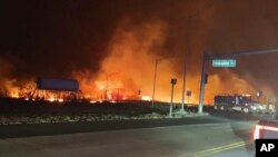 Пожежі в місті Лагайна, Гаваї. 8 серпня 2023. На цій фотографії, наданій округом Мауї, видно вогонь і дим від лісових пожеж на перехресті головних дорів на острові Мауї. (Фотобаза АP)