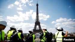 Jurnalis mengunjungi venue Stadion Menara Eiffel tempat penyelenggaraan acara voli pantai Olimpiade Paris 2024, di kaki Menara Eiffel di Paris, Prancis, 25 Juni 2024. (Benoit Tessier/REUTERS)