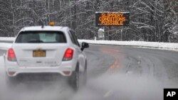 Se ve una señal de precaución en la carretera mientras los automovilistas viajan durante una tormenta de nieve invernal el martes 14 de marzo de 2023 en Albany, Nueva York (AP Photo/Hans Pennink)