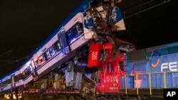 Police and firefighters inspect two trains that collided in San Bernardo, Santiago, Chile, June 20, 2024.