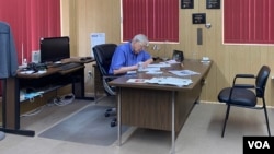 Eric Meyer edits a news article at his desk. The publisher of the Marion County Record says keeping information flowing in a town is important. (VOA/Liam Scott)