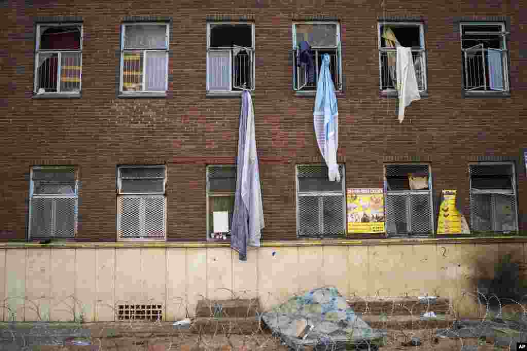 Curtains and sheets used by people trying to flee one of South Africa&#39;s deadliest inner-city fires dangle from windows, in Johannesburg, South Africa, Friday, September 1, 2023. Emergency services teams have left the scene of one of South Africa&#39;s deadliest inner-city fires as pathologists faced the grisly task Friday of identifying dozens of charred bodies and some separate body parts that had been transported to several mortuaries across the city of Johannesburg.&nbsp;