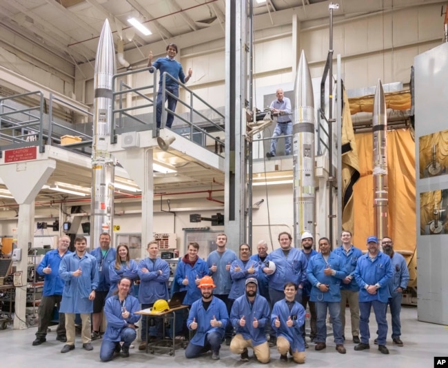 This NASA photo show agency workers standing in front of three APEP rockets at NASA Wallops Flight Facility on Wallops Island, Va., on Feb. 21, 2024. (Berit Bland/NASA via AP)