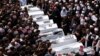 Druze elders and mourners surround the coffins of 10 of the 12 people killed in a rocket strike from Lebanon a day earlier, during a mass funeral in the Druze town of Majdal Shams in the Israel-annexed Golan Heights, July 28, 2024. 