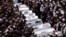 Druze elders and mourners surround the coffins of 10 of the 12 people killed in a rocket strike from Lebanon a day earlier, during a mass funeral in the Druze town of Majdal Shams in the Israel-annexed Golan Heights, July 28, 2024. 