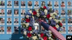 A wreath of flowers placed by U.S. President Joe Biden is seen at a memorial wall dedicated to Ukrainian soldiers killed in Russia's war against its neighbor, in Kyiv, Feb. 20, 2023.