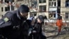 A Ukrainian police officer evacuates an injured elderly woman after a shelling in the town of Kramatorsk on March 14, 2023. 