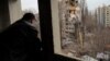 ওডেসায় রুশ ড্রোন হামলায় ক্ষতিগ্রস্ত একটি অ্যাপার্টমেন্ট ভবনের দিকে তাকিয়ে আছেন এক বাসিন্দা (২ মার্চ, ২০২৪)