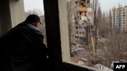 ওডেসায় রুশ ড্রোন হামলায় ক্ষতিগ্রস্ত একটি অ্যাপার্টমেন্ট ভবনের দিকে তাকিয়ে আছেন এক বাসিন্দা (২ মার্চ, ২০২৪)