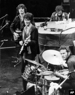 FILE - The Band - Richard Manuel on piano, Levon Helm on drums, guitarist Robbie Robertson, center, bassist Rick Danko, and organist Garth Hudson (not shown), play at Winterland Auditorium in San Francisco, Nov. 27, 1976. It was their final live show.