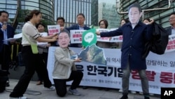 South Korean protesters wearing masks with the faces of Japanese Prime Minister Fumio Kishida, right, and South Korean President Yoon Suk Yeol are seen during a rally prompted by a dispute with Japan over the social media app Line, in Seoul, May 14, 2024. 
