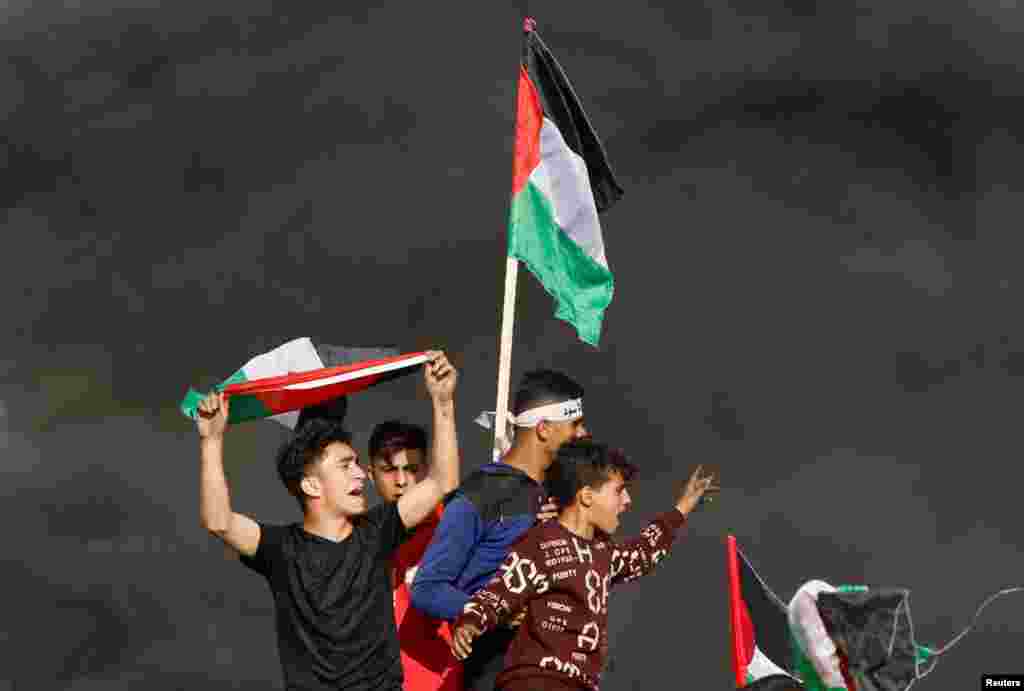 Palestinians take part in a protest against the annual flag march in Jerusalem which marks Jerusalem Day, at the Israel-Gaza border fence east of Gaza City.
