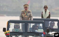 Senior Gen. Min Aung Hlaing, left, head of the military council, inspects officers during a parade to commemorate Myanmar's 78th Armed Forces Day in Naypyitaw, Myanmar, Monday, March 27, 2023.