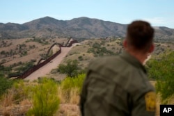 미국 애리조나주 노갈레스 미국-멕시코 국경의 미국 쪽 언덕 위에서 국경수비대가 장벽을 바라보고 있다.