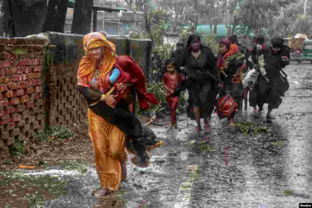 People evacuate to take shelter in the nearest cyclone shelter at Shah Porir Dwip during the landfall of cyclone Mocha in Teknaf, Bangladesh, May 14, 2023.