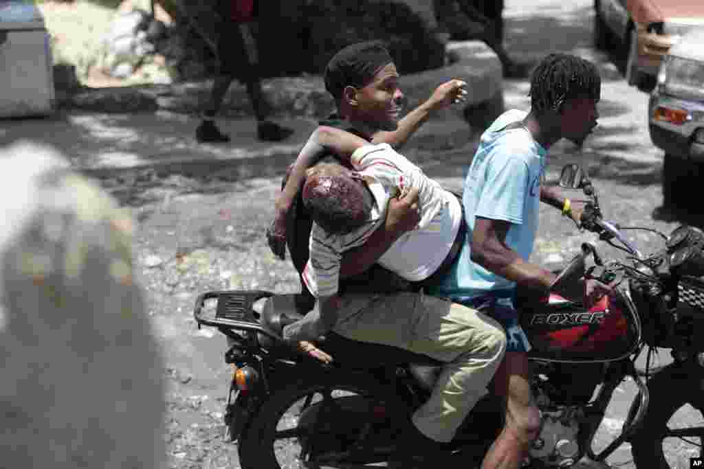 People take a man who was shot in the head during violent gang clashes, to a hospital in the Carrefour-Feuilles district of Port-au-Prince, Haiti, Aug. 15, 2023.