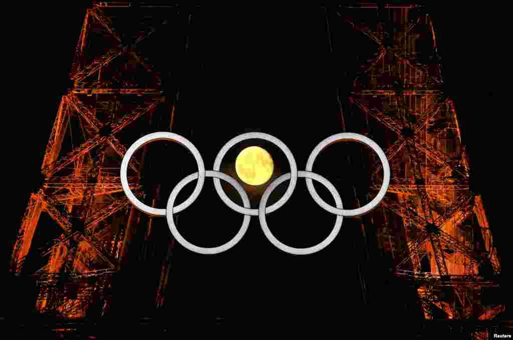 The moon is pictured with the Olympic rings on the Eiffel Tower ahead the Paris 2024 Olympic and Paralympic Games in Paris, France. REUTERS/Kai Pfaffenbach