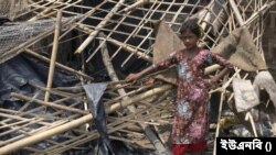 মোখার আঘাতে ক্ষতিগ্রস্ত বাড়ির সামনে এক কিশোরী।