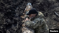 Ukrajinski vojnik stoji u blizini tenka, dok se ruski napad na Ukrajinu nastavlja, u blizini grada Bakhmuta, Ukrajina, 10. aprila 2023.