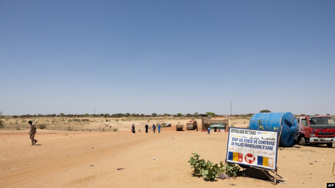 FILE - People cross the border between Sudan and Chad at the border post in Adre on April 11, 2024. 