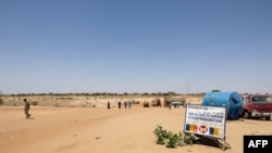 FILE - People cross the border between Sudan and Chad at the border post in Adre on April 11, 2024. 