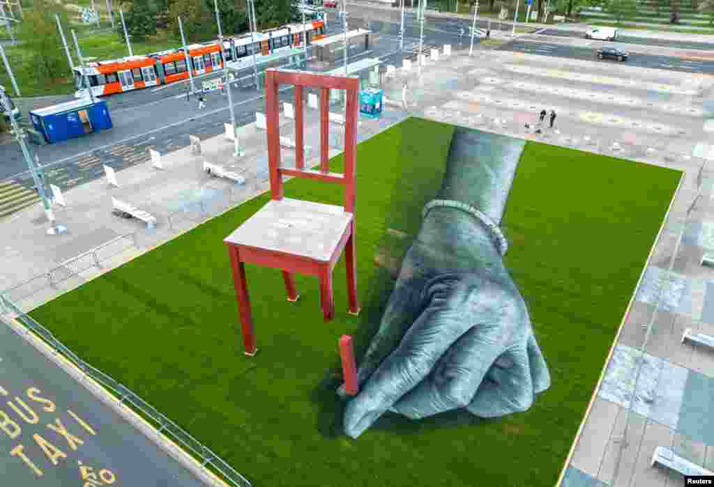 A land art painting called &nbsp;&quot;ALL OF US!&quot;&nbsp;made by Swiss French artist SAYPE is seen together with&nbsp;Broken Chair on the Place des Nations in front of the United Nations in Geneva, Switzerland, Sept. 11, 2023, to draw attention to the plight of civilians in armed conflicts. REUTERS/Denis Balibouse