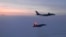 FILE - In this March 9, 2020, photo released by the North American Aerospace Defense Command (NORAD), a Russian Tu-142 maritime reconnaissance aircraft, top, is intercepted near Alaska. NORAD said it tracked two Russian and two Chinese aircraft off the coast of Alaska.