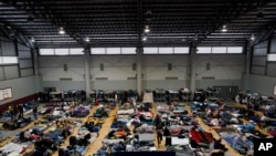 FILE - Ukrainian refugees wait in a gymnasium Tuesday, April 5, 2022, in Tijuana, Mexico.