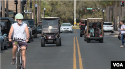 Bicycles, golf carts and vehicles on the move in The Villages, Florida, Feb. 27, 2023. (Photo by Adam Greenbaum/VOA)