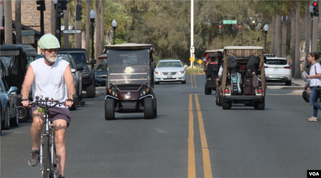 Bicycles, golf carts and vehicles on the move in The Villages, Florida, Feb. 27, 2023.