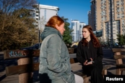 ARCHIVO - Liza Batsura y su madre Oksana conversan en un banco en Kiev, Ucrania, 11 de octubre de 2023. REUTERS/Alina Smutko