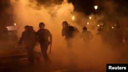 French CRS riot police run amid clashes with protesters during a demonstration as part of the ninth day of nationwide strikes and protests against French government's pension reform, in Paris, France, March 23, 2023.