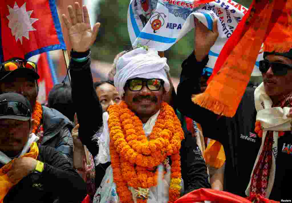Gurkha veteran Hari Budha Magar, the first above-the-knee double amputee to scale Mount Everest, waves towards the media upon his arrival in Kathmandu, Nepal.