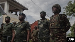 Des soldats de la République démocratique du Congo (RDC) et du Kenya montent la garde au siège de la Communauté de l'Afrique de l'Est (EAC) à Goma, dans l'est de la RDC, le 16 novembre 2022.