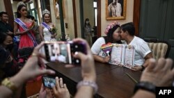 FILE - An LGBTQIA+ couple poses for photos as they receive customed marriage certificates, despite Thailand not recognizing same-sex marriages, during a symbolic marriage registration event in Bangkok, Feb. 14, 2023.