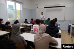 Middle school students, some wearing a hijab, listen to teacher Ilyas Laarej during an Islamic ethics class at the Averroes school, France's biggest Muslim educational institution that has lost its state funding, Lille, France, March 19, 2024.