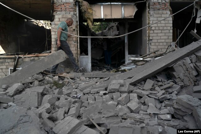 FILE - A man walks over debris of a psychiatric hospital that was heavily damaged after a Russian attack in Kramatorsk, Ukraine, Sept. 7, 2022. (AP Photo/Leo Correa, File)