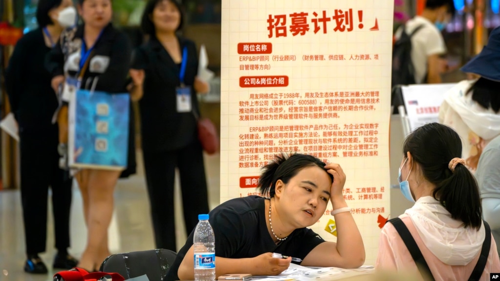 资料照片: 2023年6月9日北京一家购物中心招聘会上一名招聘人员与应聘者交谈(photo:VOA)