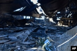 Flowers are placed inside a damaged factory where one person was found dead in a suburb of Athens on Aug. 13, 2024, in the wake of a major wildfire.