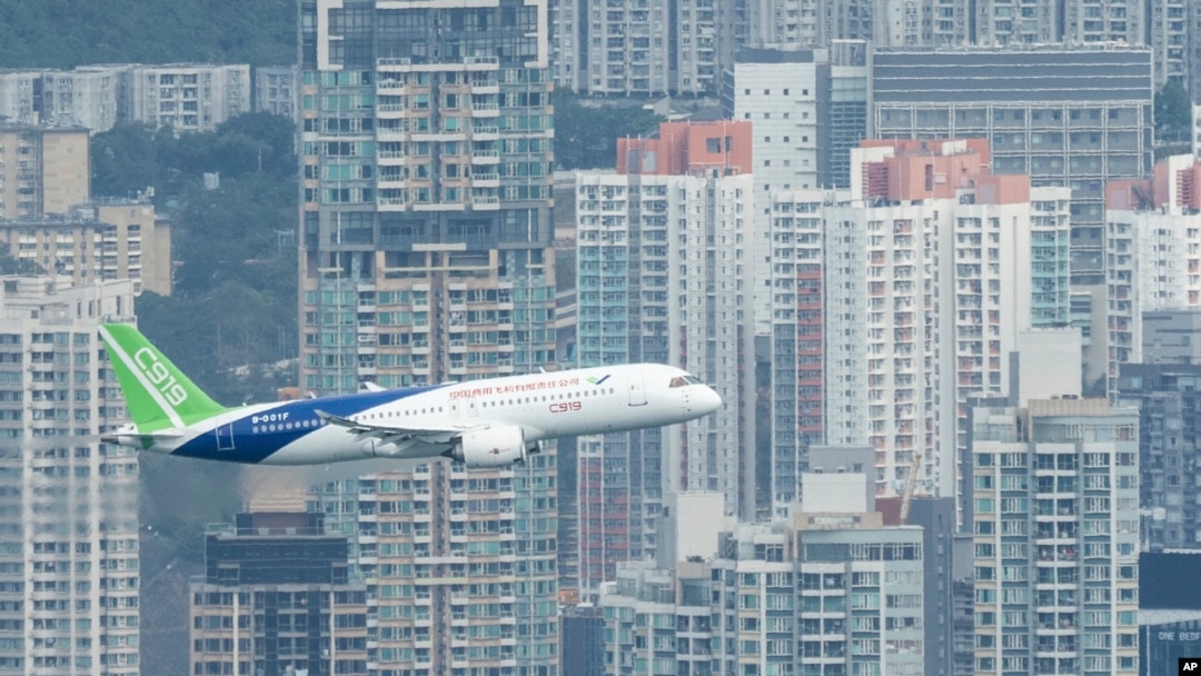 FILE - A Chinese-made C919 flies over Hong Kong's Victoria Harbor in Hong Kong, on Dec. 16, 2023.