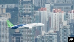 FILE - A Chinese-made C919 flies over Hong Kong's Victoria Harbor in Hong Kong, on Dec. 16, 2023.