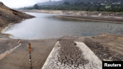 A measuring bar is exposed by the low water level in the San Rafael reservoir in La Calera, Colombia, April 8, 2024. Bogota will start rationing water this week to alleviate droughts wrought by the El Nino weather pattern.